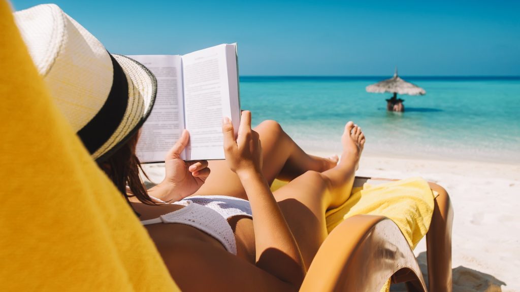 Woman Reads Book Tropical Island Beach Istock 664474198.jpg