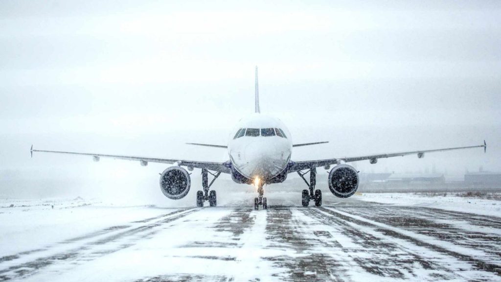 A Passenger Plane On A Runway In A Blizzard 1 1600x900.jpeg